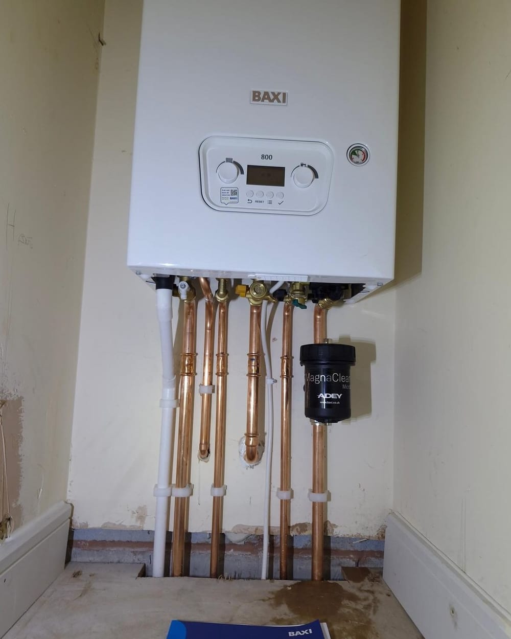 Copper pipework and a magnetic filter under a newly fitted boiler, from the team doing oil boiler installation in Llantwit Major