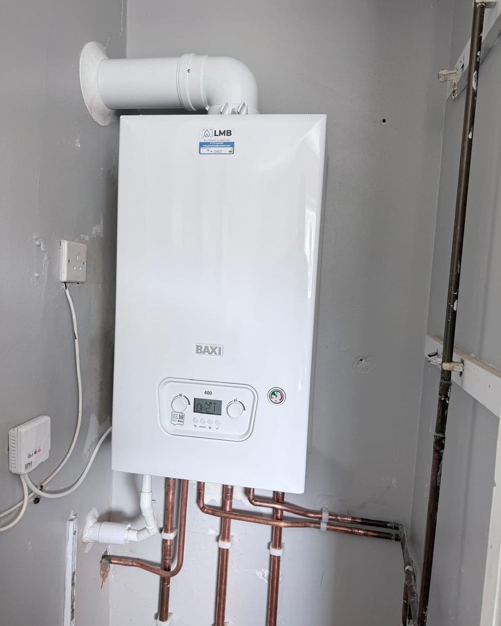A boiler with its flue on a utility room wall